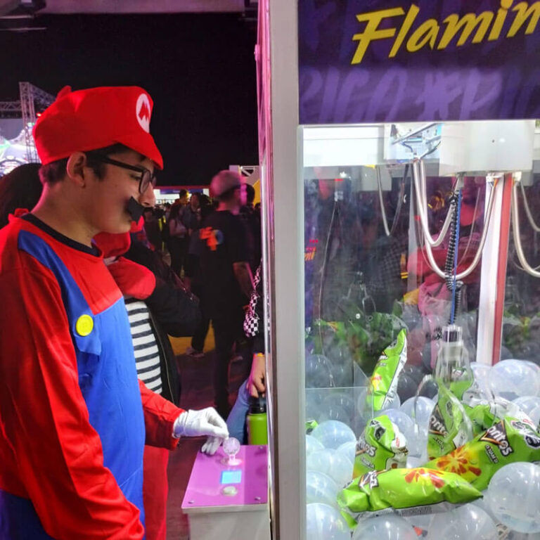 Participante con disfraz de Mario jugando en la peluchera Flamin Hot