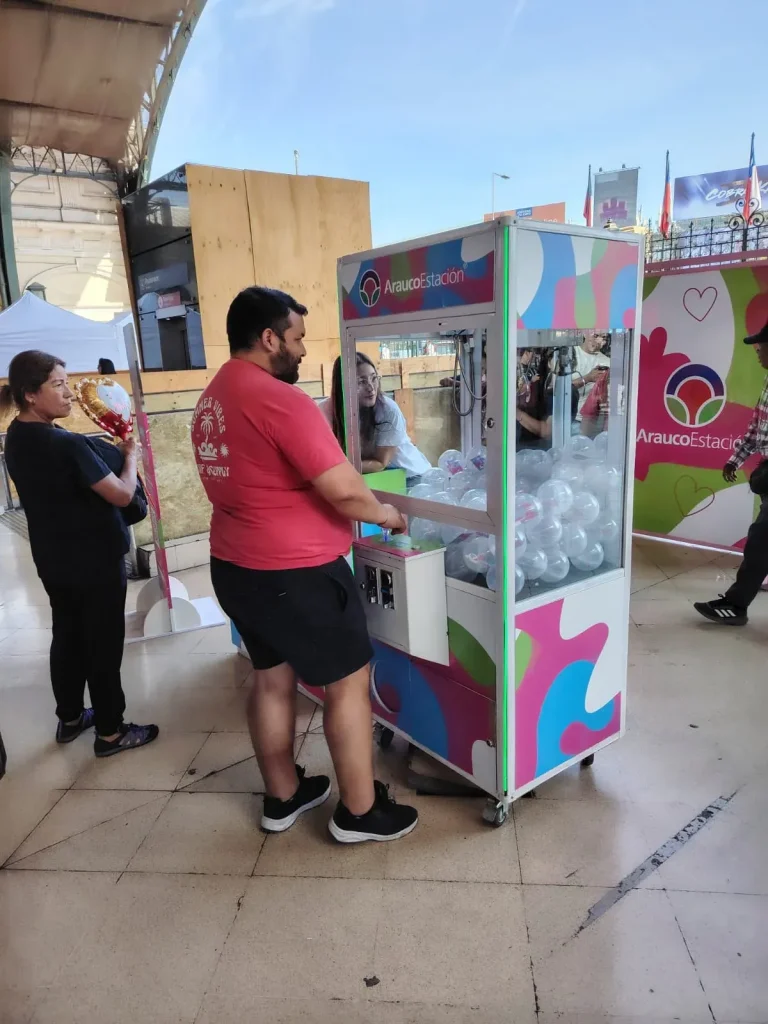 Peluchera de Arauco Estación cargada con esferas de premios y un participante jugando