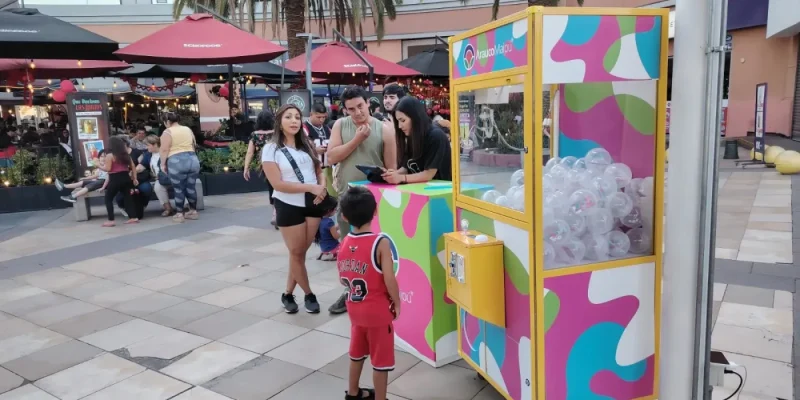 Niño frente a la peluchera colorida de Arauco en el paseo exterior del mall