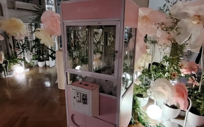 Peluchera Kérastase rosada ambientada con decoración floral en un evento de belleza