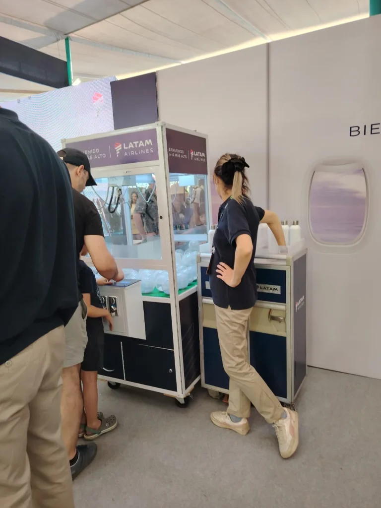 Familia jugando en la peluchera personalizada de LATAM Airlines durante un evento