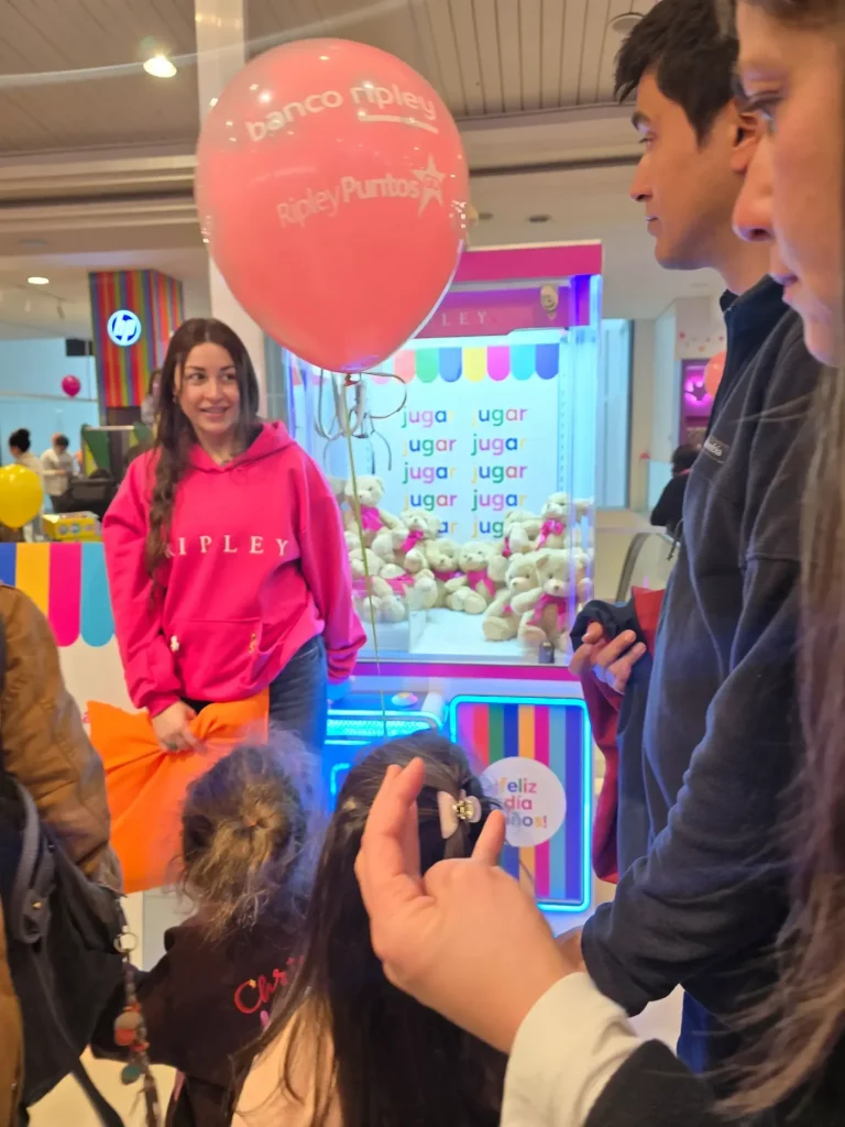 Clientes disfrutando de la peluchera interactiva de Ripley en evento corporativo