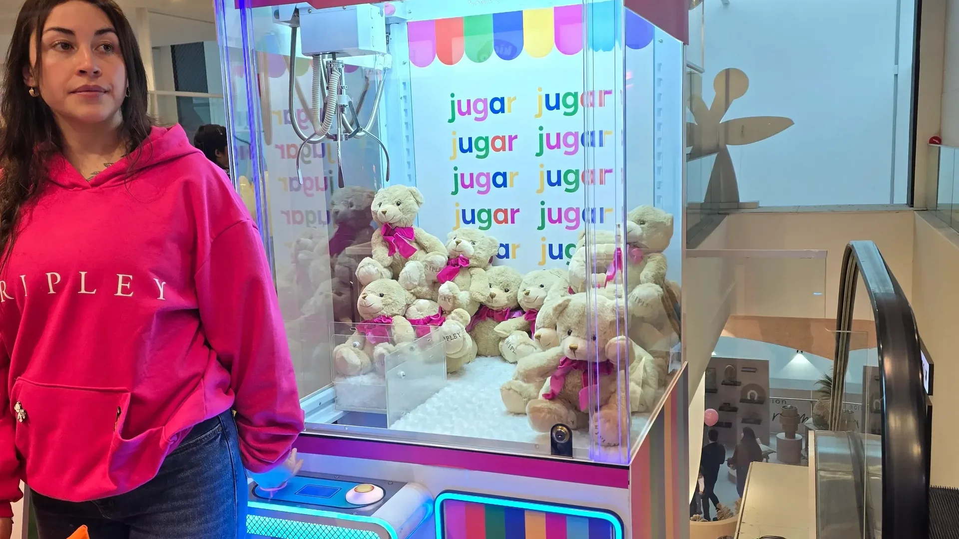 Anfitriona junto a una peluchera rosada personalizada de Ripley llena de ositos de peluche en una activación de marca