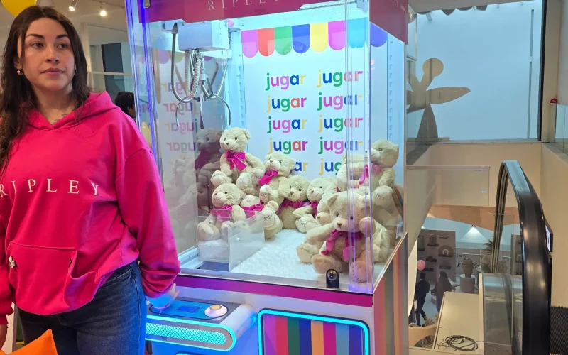 Anfitriona junto a una peluchera rosada personalizada de Ripley llena de ositos de peluche en una activación de marca