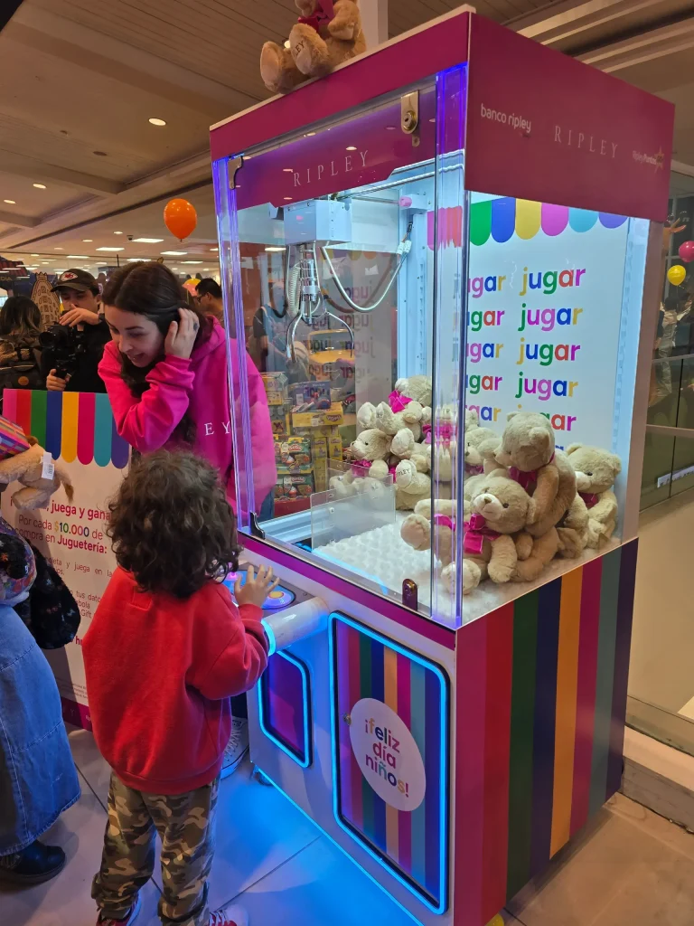 Madre e hijo jugando juntos en una peluchera rosada con ositos de peluche en un evento familiar