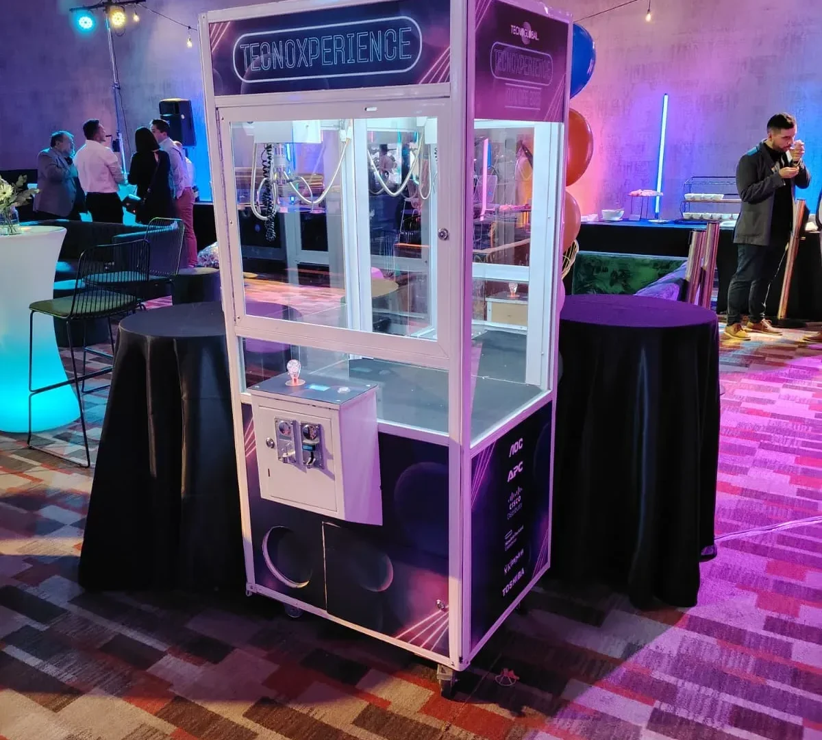 Peluchera personalizada Tecnoxperience iluminada con luces neón en un evento corporativo