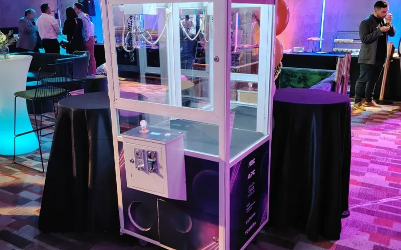 Peluchera personalizada Tecnoxperience iluminada con luces neón en un evento corporativo