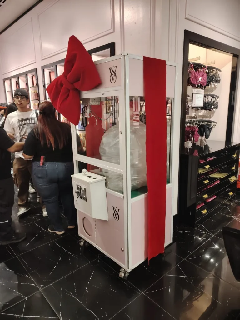 Peluchera personalizada Victoria's Secret decorada con un gran lazo rojo dentro de la tienda